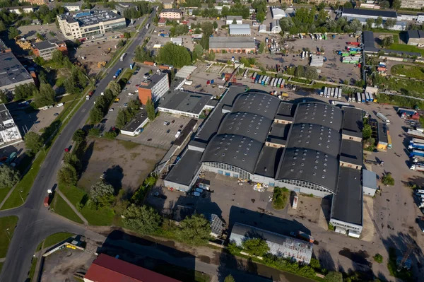 Summer cityscape of modern european city. Top drone view of warehouse.