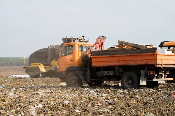 Waste sorting on landfill of big city. A lot of garbage. Truck with manual hydraulic manipulator. Heavy equipment.