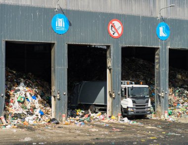 Büyük bir endüstriyel atık deposu. Büyük şehir çöplüğü. Beyaz çöp kamyonu. Geri dönüşüm için hazırlık.