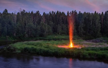 Geceleri ormanın ve nehrin manzarası. Büyük bir yangın. Yaz ortası.