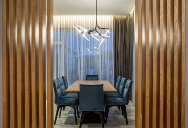 Lüks özel evdeki modern mutfak. Kocaman ahşap masa ve sandalyeler. Panorama pencereleri.