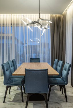 Lüks özel evdeki modern mutfak. Kocaman ahşap masa ve sandalyeler. Panorama pencereleri.