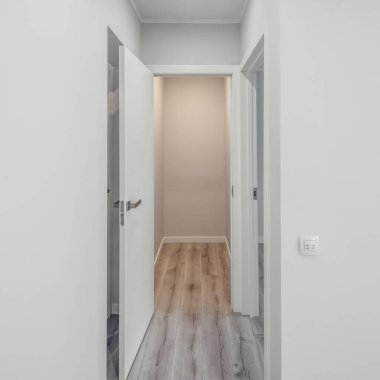 Lüks dairede modern, parlak bir salon. Beyaz duvarlar. Bej parke zemin.