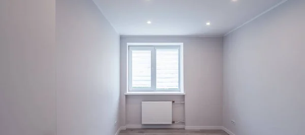 Modern ljus interiör i tomt renoverat rum. Vita väggar. Ljust golv. Vägg med fönster. — Stockfoto