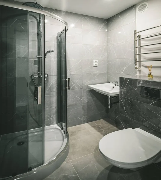 Modernes Interieur des Badezimmers in einer Luxuswohnung. Graue Marmorfliese. Weißes Waschbecken und Toilette. Dusche. — Stockfoto