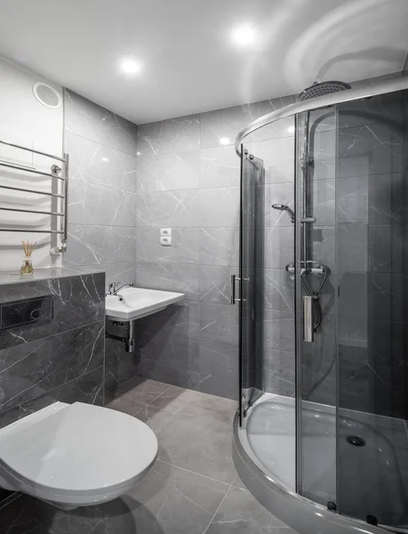 Interno contemporaneo del bagno in appartamento moderno. Mattonelle di marmo grigio. Cabina doccia in vetro. Lavandino e servizi igienici. — Foto Stock