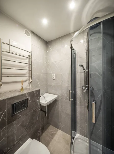 Interno contemporaneo del bagno in appartamento moderno. Mattonelle di marmo grigio. Cabina doccia in vetro. Lavandino e servizi igienici. — Foto Stock