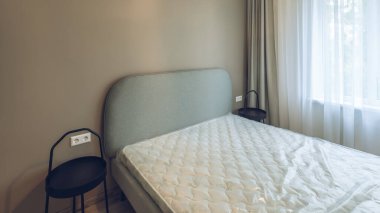 Modern iç mekan. Yatak odası dairede. Bej duvar. Yatakta yeni bir yatak