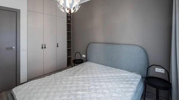 Intérieur moderne. Chambre en appartement. Mur beige. Nouveau matelas sur le lit — Photo