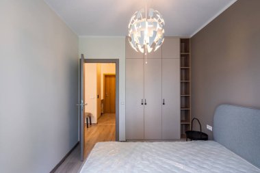 Modern iç mekan. Yatak odası dairede. Bej duvar. Yatakta yeni bir yatak