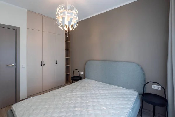 Intérieur moderne. Chambre en appartement. Mur beige. Nouveau matelas sur le lit — Photo