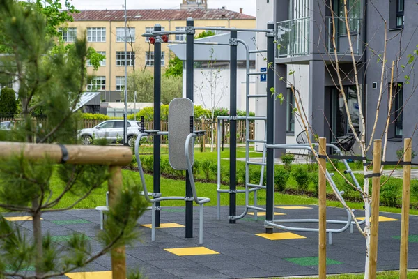 Bahçedeki çocuk parkında egzersiz aletleri. Modern konut binası.