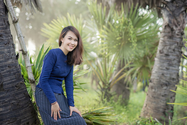 Thai Farmer woman wearing typical Thai dress, on Rice fields bac