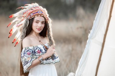 Boho bohem kız sonbahar tarlasında Hint Maxi elbisesi ve mücevheri giyer.