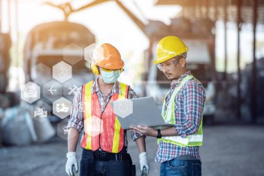 Metal torna fabrikasında dizüstü bilgisayar kullanırken fabrika işçisi olan profesyonel endüstriyel makine mühendisi. Mühendis, fabrikada projeler üzerinde çalışıyor.