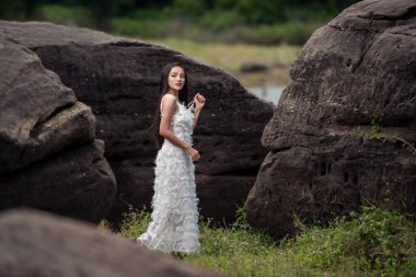 Güzel bir gelinin düğün portresi. Asyalı bir kadın. Taş ve orman tasarımcısının muhteşem gelinliği.