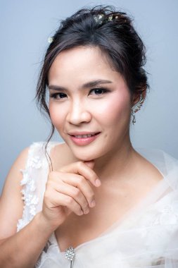 Beyaz arka planda gelin gibi giyinmiş güzel Asyalı kadın.