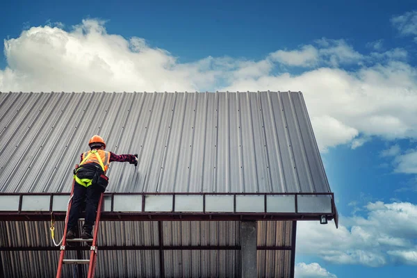 Worker man building on the roof of a house