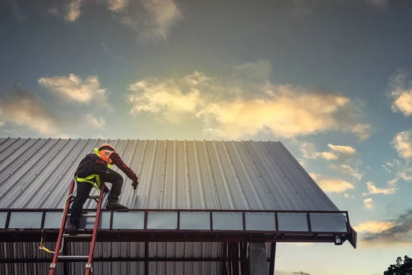 Worker man building on the roof of a house