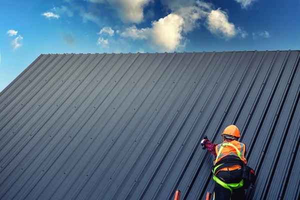 Worker man building on the roof of a house