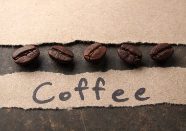 Kahve çekirdekleri ile kağıt ahşap doku arka plan üzerinde kırpma