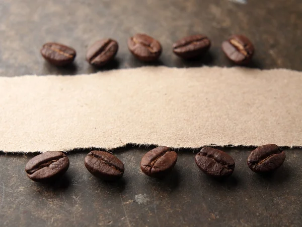 Coffee crop beans with paper on wood texture background — Stock Photo, Image