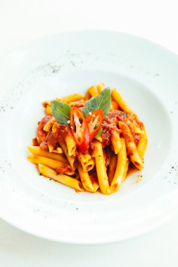 Beyaz çanak üzerinde domates soslu Penne