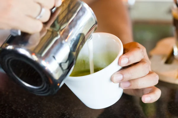 Barista hands pouring milk making milk green tea — Stock Photo, Image