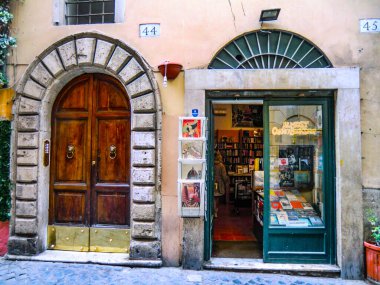 Mayıs 2021 'de, Roma, İtalya' da Trastevere 'de eski, rahat sokaklardaki bir kitapçının yanındaki eski ahşap kapı. Roma 'nın Trastevere Mahallesi, Tiber' in batı kıyısında, Roma şehrinin mimarisi ve simgesi, Lazio, Avrupa