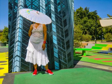 Japon güneş şemsiyeli bir kadın, Yeşil ve Peyzaj Festivali işbirliğiyle Musica 'nın Roman başına düşen sanat müdahalesi kapsamında BIODiVERCITY' de bir resim için poz veriyor. Sanatçı Ciriaco Kampüsü tarafından tasarlandı, 1000 metre