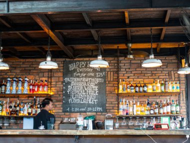 Bali 'deki barakalarda içki ve şişe sıraları sergileniyor ve içeride mutfak açacak kimlikleri belirsiz insanlar var. Bali, Endonezya, Ağustos 2025