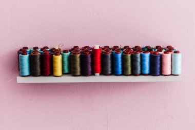 Bali 'de kadınlar için süslü bir terzilik atölyesi, ünlü stilistin duvar çizimleri ve yazıları var. Duvarda renkli iplik makaraları var. Bali, Endonesi, Ağustos 2025            