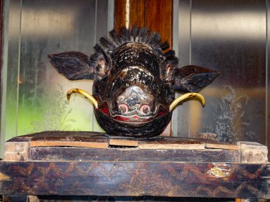 Çok eski maskeler ve ahşap oyulmuş eşyalar, Puputan Klungkung Anıtı 'nın içinde modern maskelerle karıştırılmış. Bali, Endonezya, Ağustos 2025