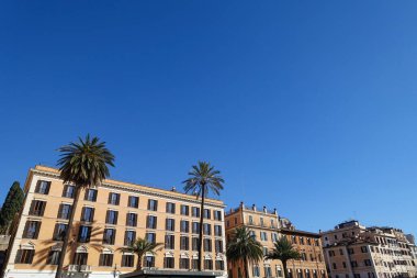 Piazza di Spagna - Roma, İtalya - İspanyol basamakları. İspanyol Scalinata di Trinita dei Monti, güneşli günün tadını çıkaran turistlerle dolu Roma, İtalya 'ya adım atıyor ve güzel mimari ve fotoğraf çekiyor. Trinita dei Monti Kilisesi manzarası.