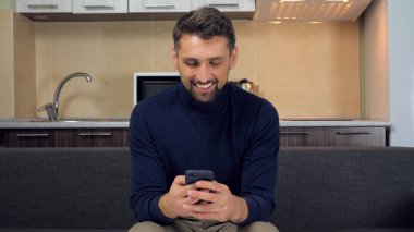 Akıllı telefonu elinde tutan kuryeyle iletişim kuran adam telefon daktilo mesajı kullanıyor.