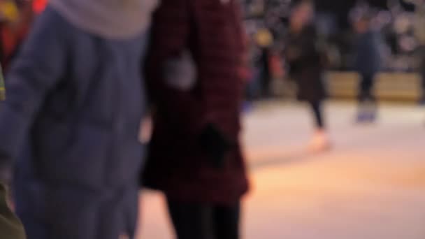 Desenfoque hombres mujeres niños patinan sobre hielo en invierno. Ambiente de Navidad de Año Nuevo — Vídeos de Stock