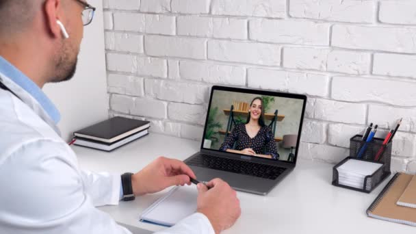 Lekarz w gabinecie szpitalnym wita konsultację pacjentka klient kobieta online laptop — Wideo stockowe