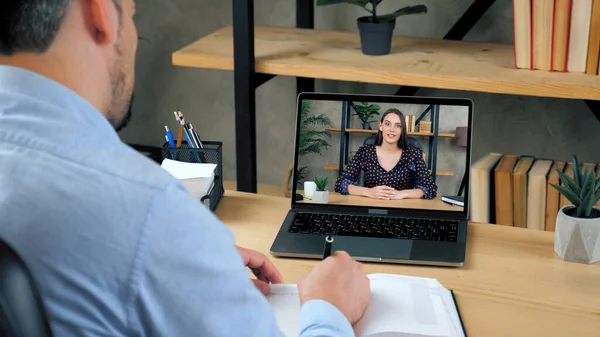 Mann studiert online per Videokonferenz Laptop, schreibt in Notizbuch — Stockfoto