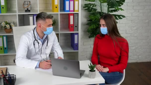 Доктор чоловік і пацієнт носять захисні маски на обличчях у лікарнях — стокове відео