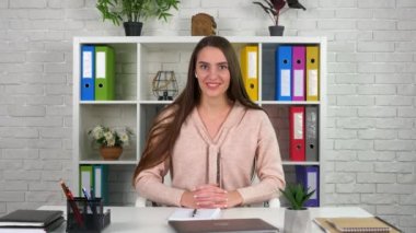 Gülümseyen kadın öğretmen internetteki görüntülü konuşma konferansında öğrenciyle iletişim kuruyor.