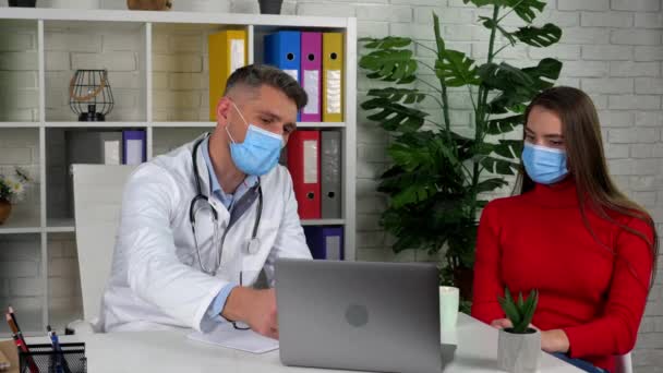 Doctor shows tells patient causes health problems on laptop, client drink coffee — Stock Video