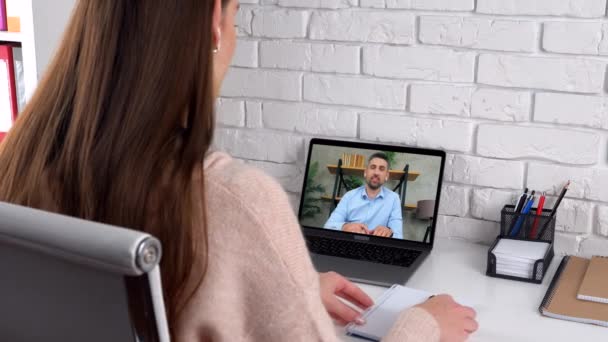 Žena student studium on-line video hovor notebook, píše v notebooku poslouchat učitel — Stock video