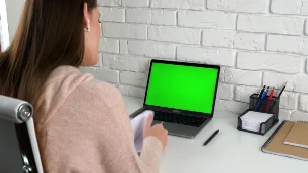 Managerin sucht Informationen in Notizbuch-Gespräch mit grünem Bildschirm-Laptop — Stockvideo