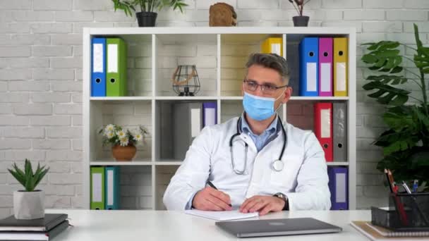 Dokter bertopeng berbicara dengan pasien, klien menunjukkan gejala penyakit — Stok Video