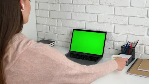 Женщина дома выглядит зеленый экран ноутбук слушать учитель репетитор пить кофе чай — стоковое видео