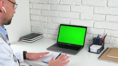 Doktor yeşil ekranlı dizüstü bilgisayar konuşması nefes alma tekniğiyle hastayı sakinleştiriyor.