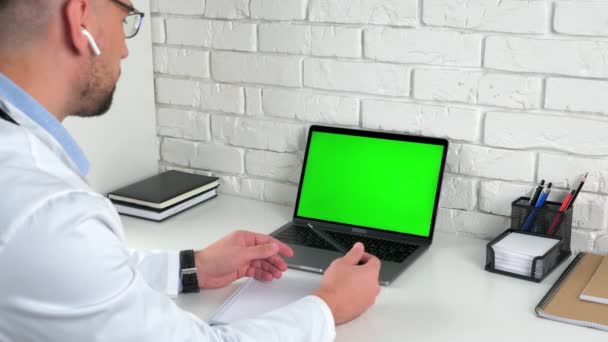 Γιατρός ψάχνει πράσινο φορητό υπολογιστή οθόνη διδάσκει σε απευθείας σύνδεση ασκούμενοι, εξ αποστάσεως εκπαίδευση — Αρχείο Βίντεο