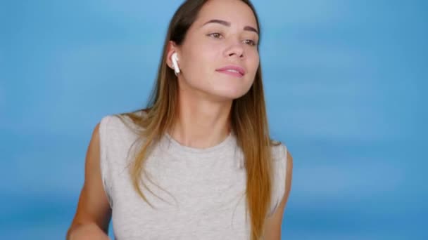 Positieve vrouw luistert naar muziek met draadloze koptelefoon, dansen, glimlachen, geniet — Stockvideo