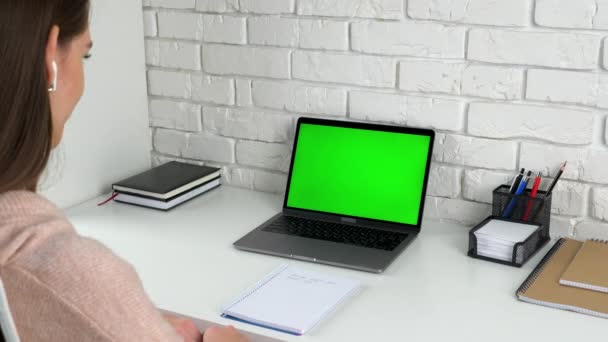 Mujer estudiante en casa asiente cabeza escucha profesor tutor con pantalla verde portátil — Vídeo de stock