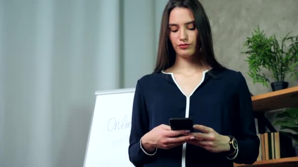 Donna d'affari che tiene il telefono in mano digitando il messaggio nei messaggeri o nei social media — Video Stock